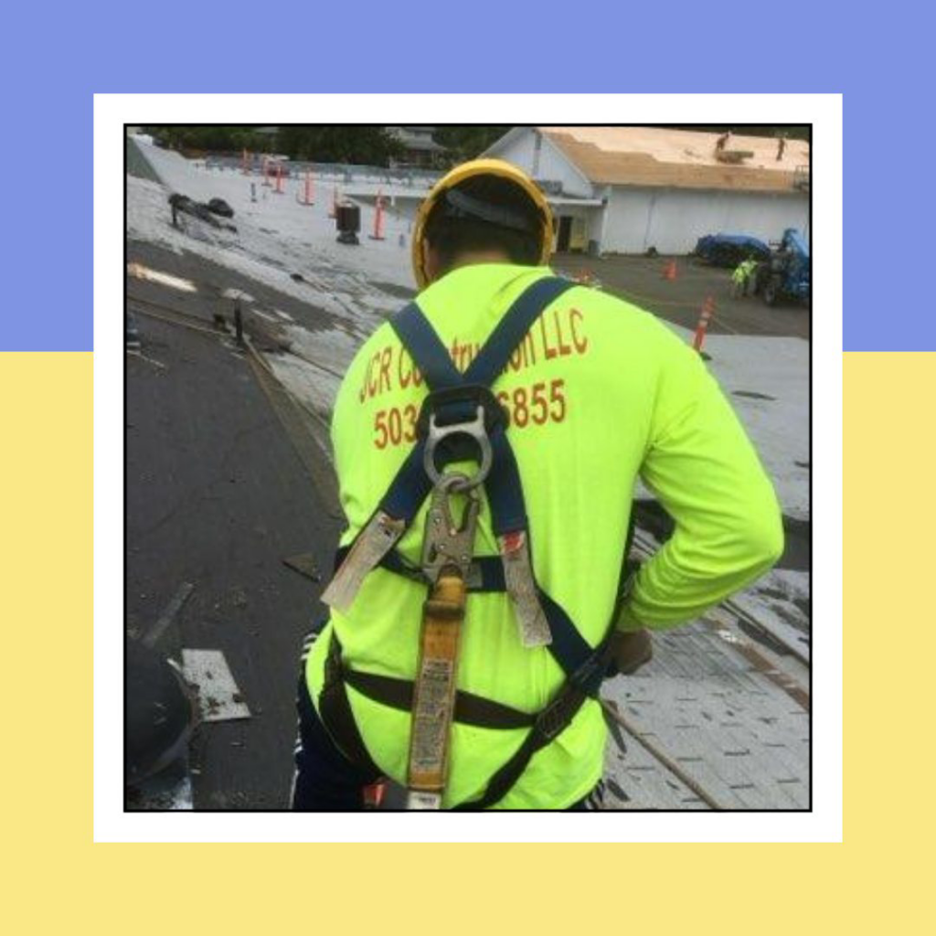 A JCR Construction LLC handyman wearing a safety harness and hard hat on a roof in Everett, WA.