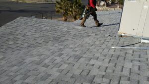 A roofer walking on a newly installed shingle roof by Villalobos Remodeling & Construction in El Paso, TX