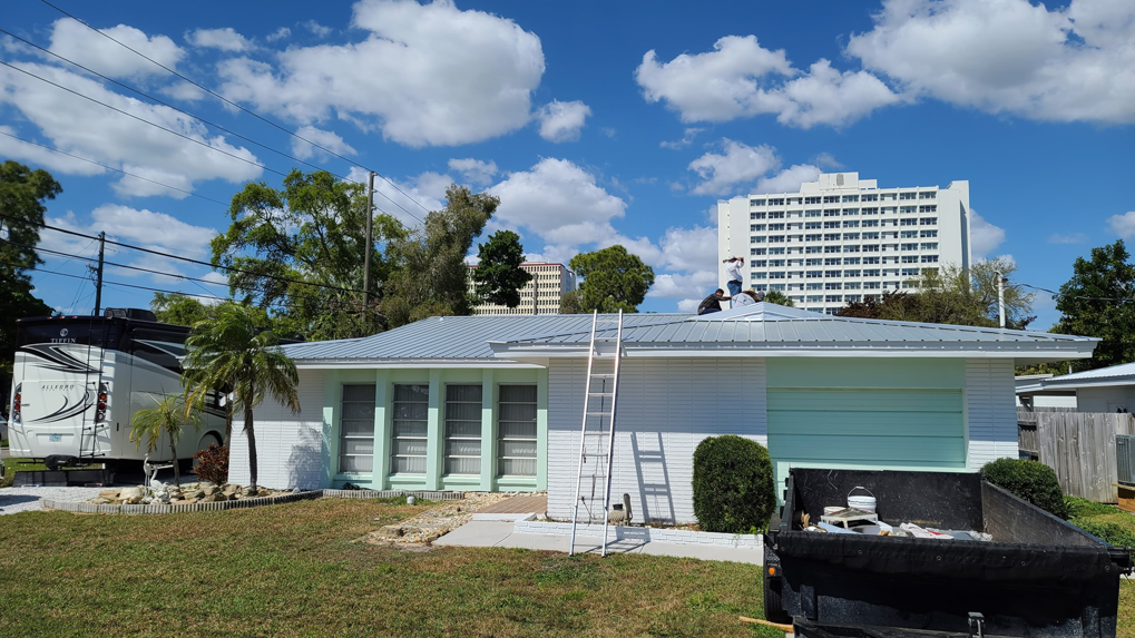 Roofers installing a new metal roof on a residential home, managed by Florida Roof & Building Services LLC in Ellenton, FL.
