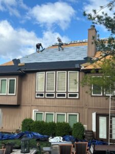 Roofers installing new shingles and underlayment on a residential home by Element Enterprises in Kansas City, MO.