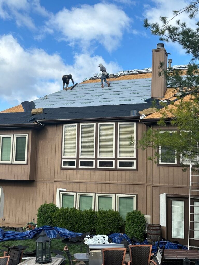 Roofers installing new shingles and underlayment on a residential home by Element Enterprises in Kansas City, MO.