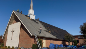 Roofers from First Choice Roofing installing new shingles on a church building in Cary, NC.