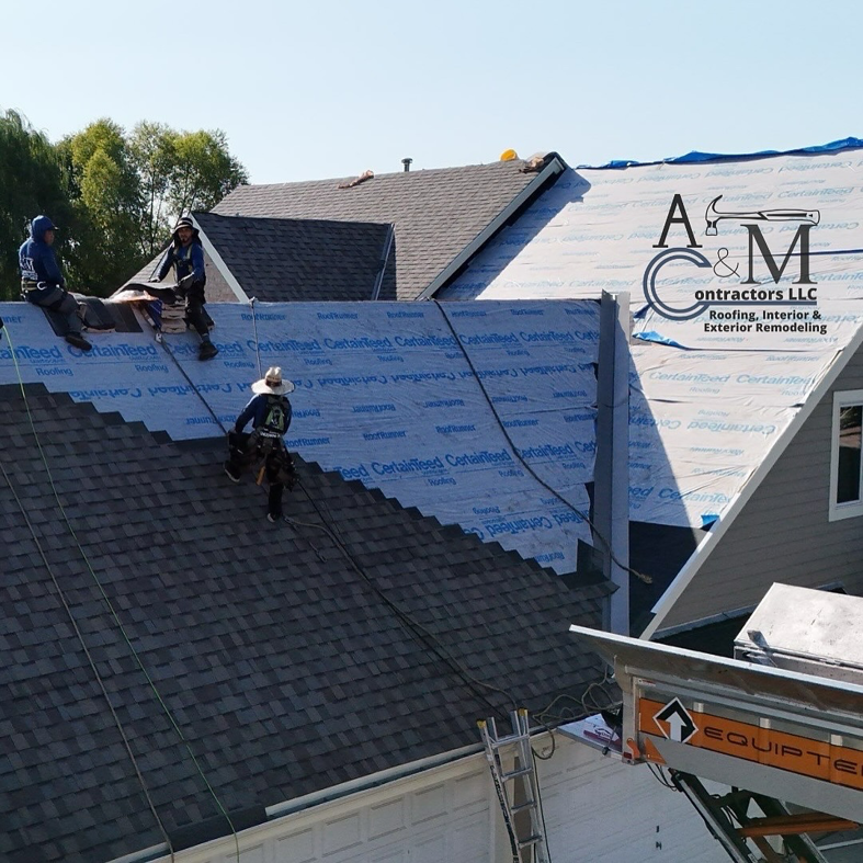 Roofers installing new shingles on a residential roof for A&M Contractors LLC in Waukesha, WI