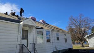 Roofers installing new shingles with bundles of materials on a house by Proline Roofing in Shipshewana, IN.