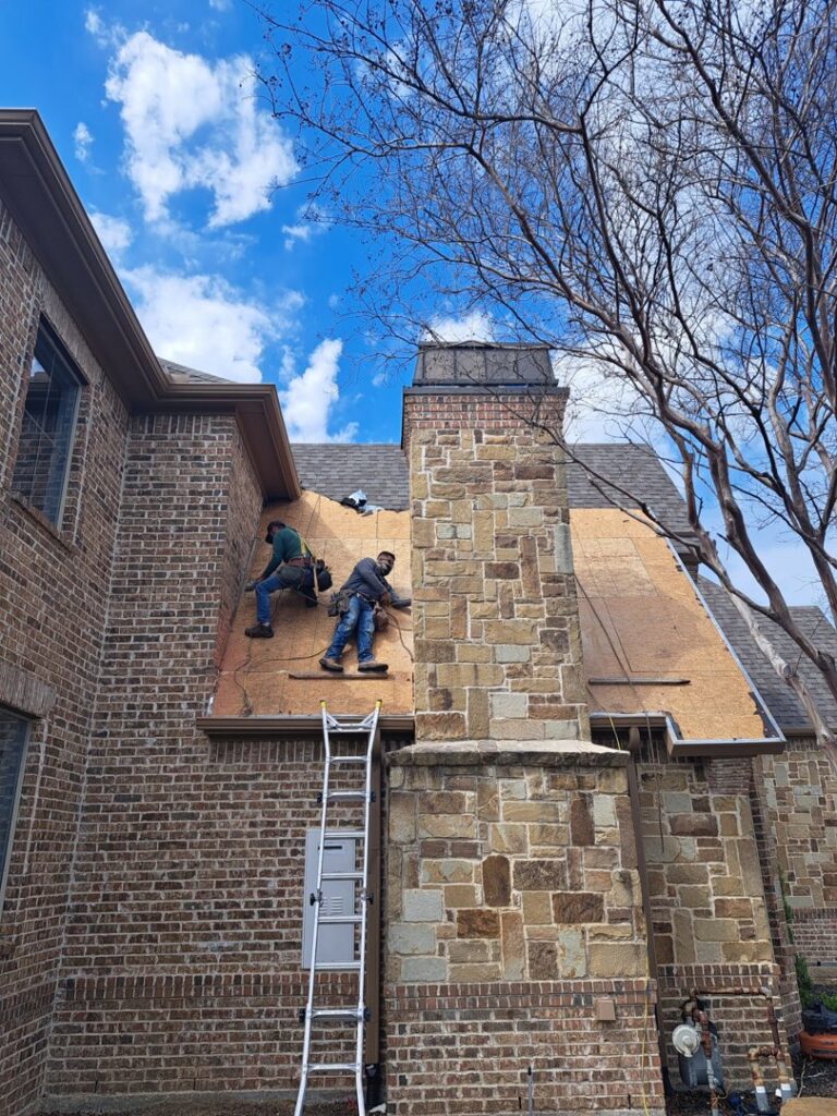 Two Riker Home Services roofers installing new shingles on a residential roof in Plano, TX