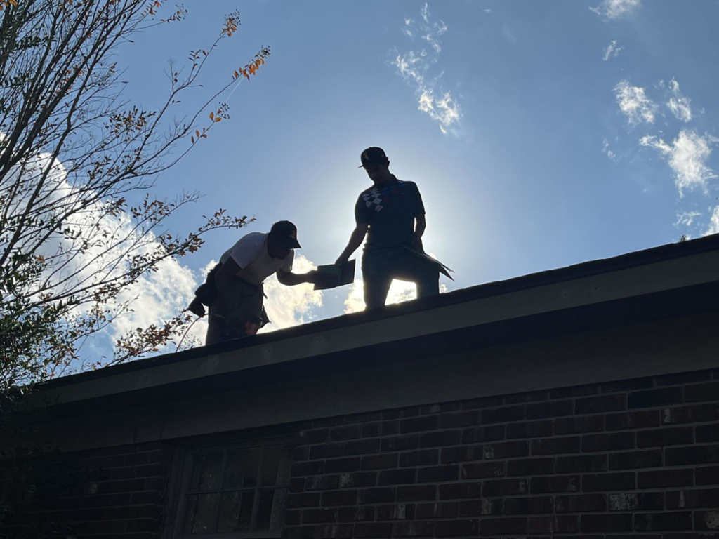 Two professional roofers installing shingles on a residential roof for Skyline Roofing L.L.C in Jackson, TN.