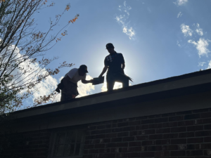 Two professional roofers installing shingles on a residential roof for Skyline Roofing L.L.C in Jackson, TN.