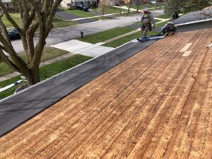 Roofing contractors installing underlayment on a residential roof deck by Pro Home Solutions in Aiken, SC.