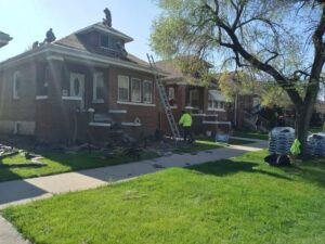 Roofers removing old shingles from a residential roof during a replacement project by Pro DK Contractor LLC in Chicago, IL.