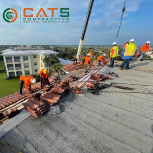 Roofers removing old roof tiles with a crane during a renovation project by CAT 5 Contracting in Jacksonville, FL