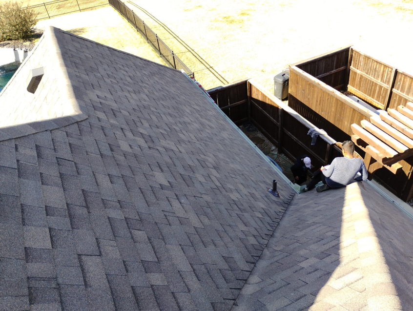 Two roofers working on a gutter installation or repair for Right Choice Roofing Oklahoma in Collinsville, OK.