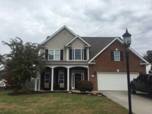 Roofers working on a residential house, with ladders and equipment, for Innovative Roofing & Siding Inc in Knoxville, TN.