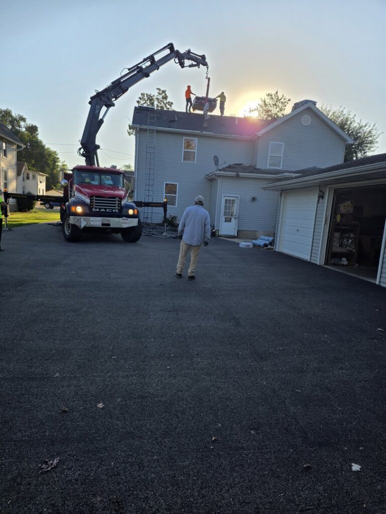 A roofing crew using a crane truck to deliver materials during a project by M&V Home Solutions Inc in Elgin, IL