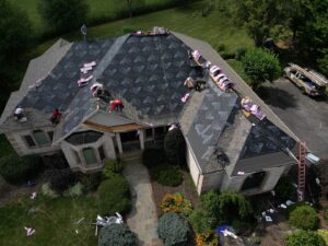 Aerial view of a roofing crew installing new shingles on a house, showcasing work by Moonshot Roofing in Columbia, PA.