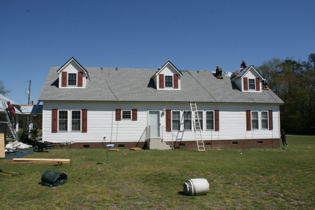 A roofing crew installing new shingles on a residential home, a handyman service by Consolidated Roofing Systems, Inc. in Cary, NC