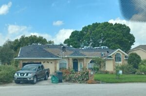 A roofing crew actively installing new shingles on a residential home, managed by Hastings Roofing Service Inc. in Orlando, FL.