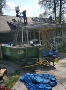 An IEG Disposal dumpster filled with roofing debris at a residential construction site in Canton, GA.