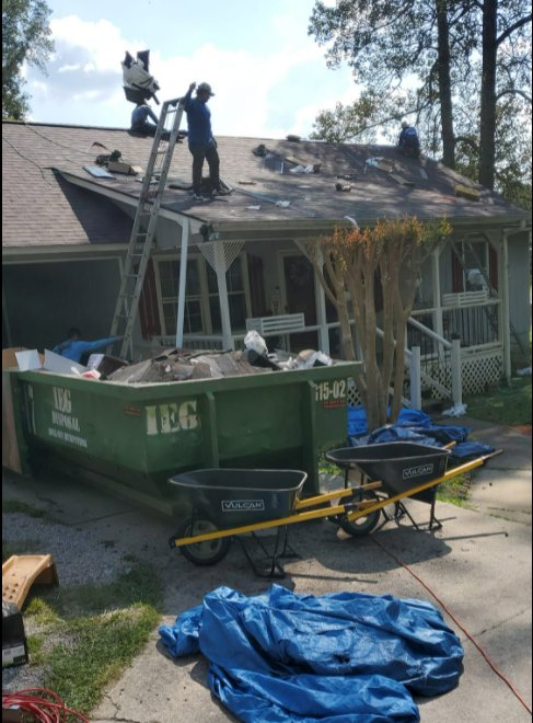 An IEG Disposal dumpster filled with roofing debris at a residential construction site in Canton, GA.