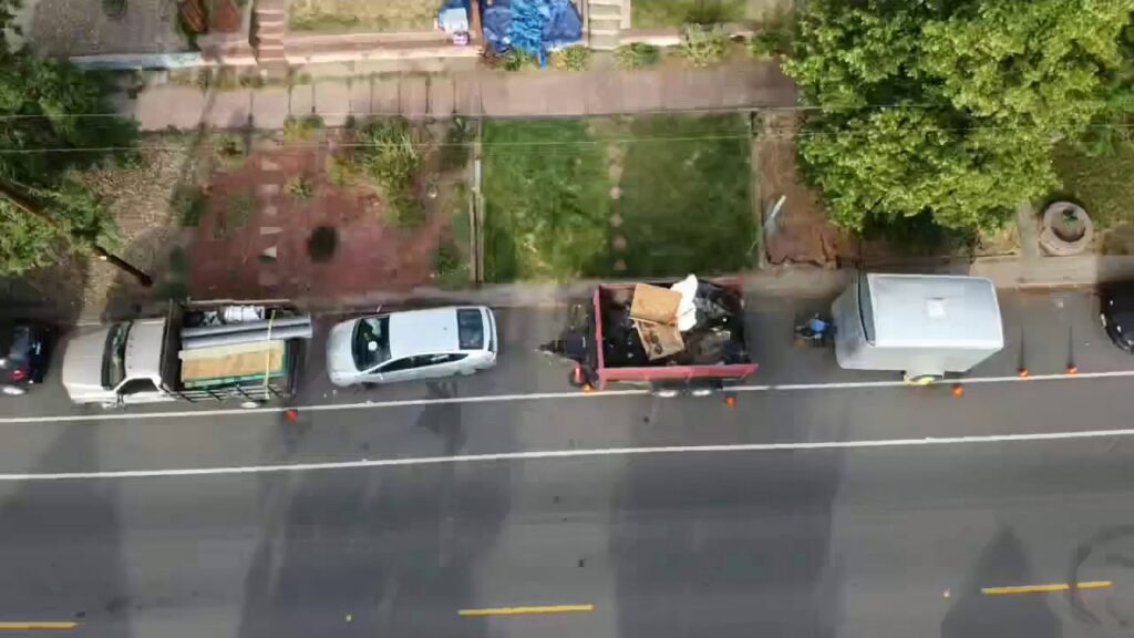 A dump trailer filled with roofing debris parked on the street for removal by Jesse Roofs Co. in Denver, CO