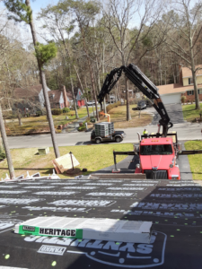 A crane truck delivering roofing materials to a residential roof for Knupp Konstruction in Salisbury, MD.