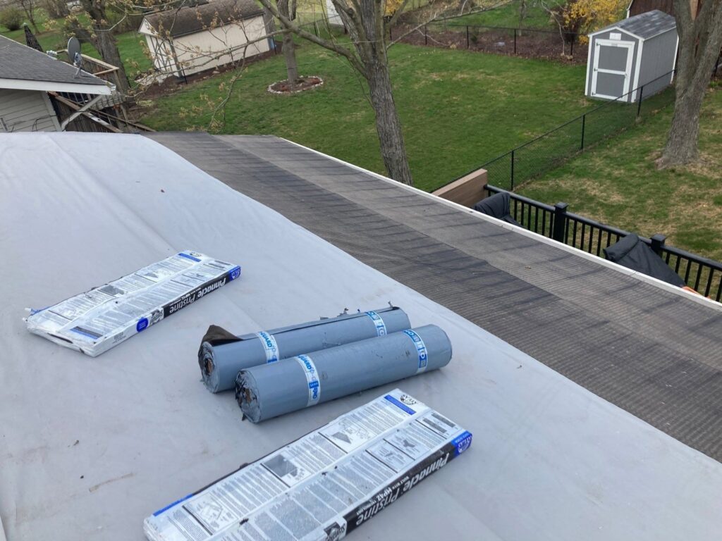 Roofing materials and underlayment rolls on a flat roof section during installation by Pro Home Solutions in Aiken, SC.