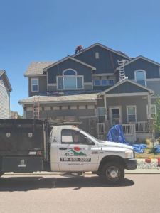 A residential roofing project in progress with a Chris Roofing & Remodeling Inc. truck parked outside in Colorado Springs, CO