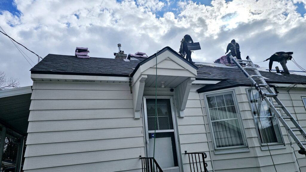 A roofing project in progress with workers and a ladder on a house by Proline Roofing in Shipshewana, IN.