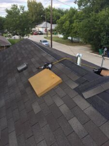 A roofing project showing newly installed shingles and a nail gun on the roof, performed by Texas Wounded Veterans Builders and Contractors in McKinney, TX.