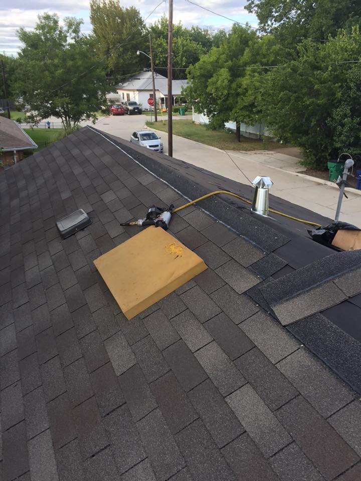 A roofing project showing newly installed shingles and a nail gun on the roof, performed by Texas Wounded Veterans Builders and Contractors in McKinney, TX.