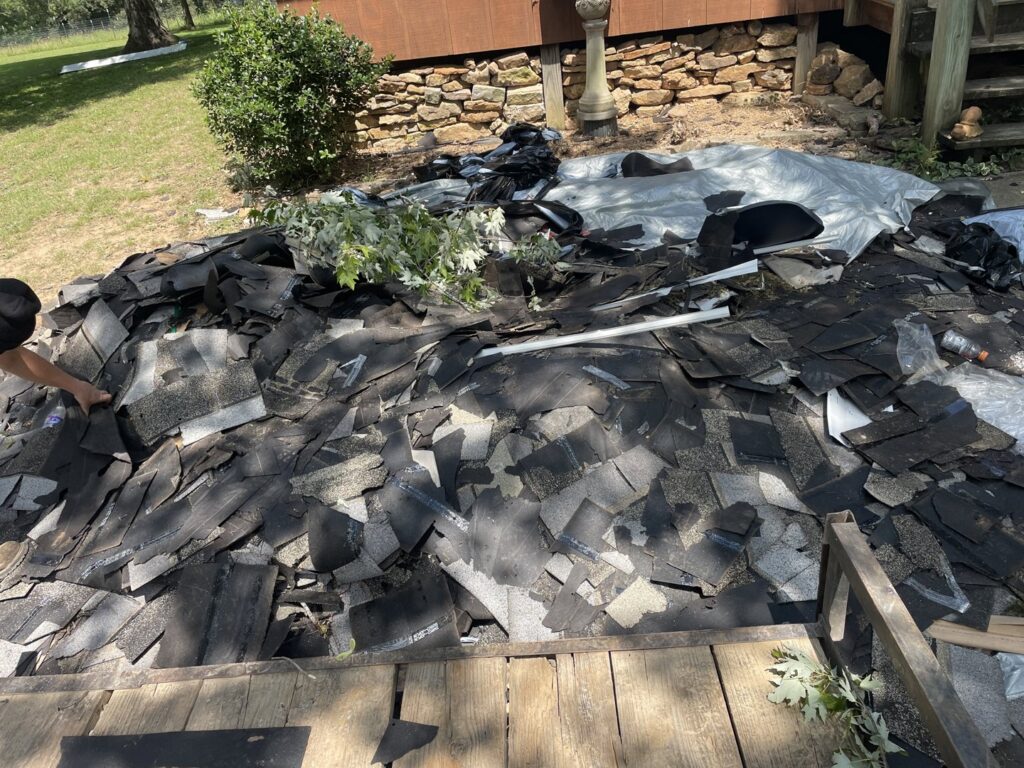 A large pile of old roofing shingles and construction debris ready for removal by DC'S Removal Service in Neelyville, MO.