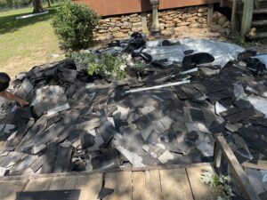 A large pile of old roofing shingles and construction debris ready for removal by DC'S Removal Service in Neelyville, MO.