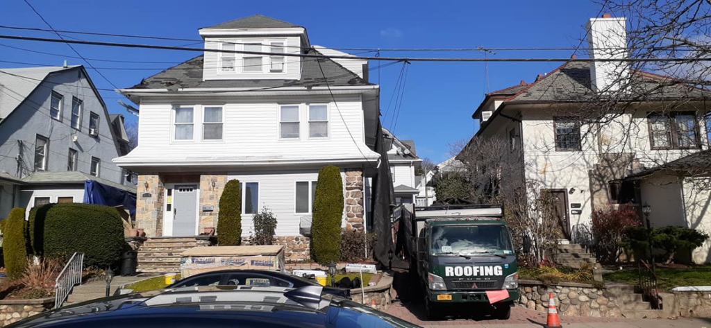 A roofing truck parked at a residential job site for Manny's Sb Construction Inc in Goshen, NY.