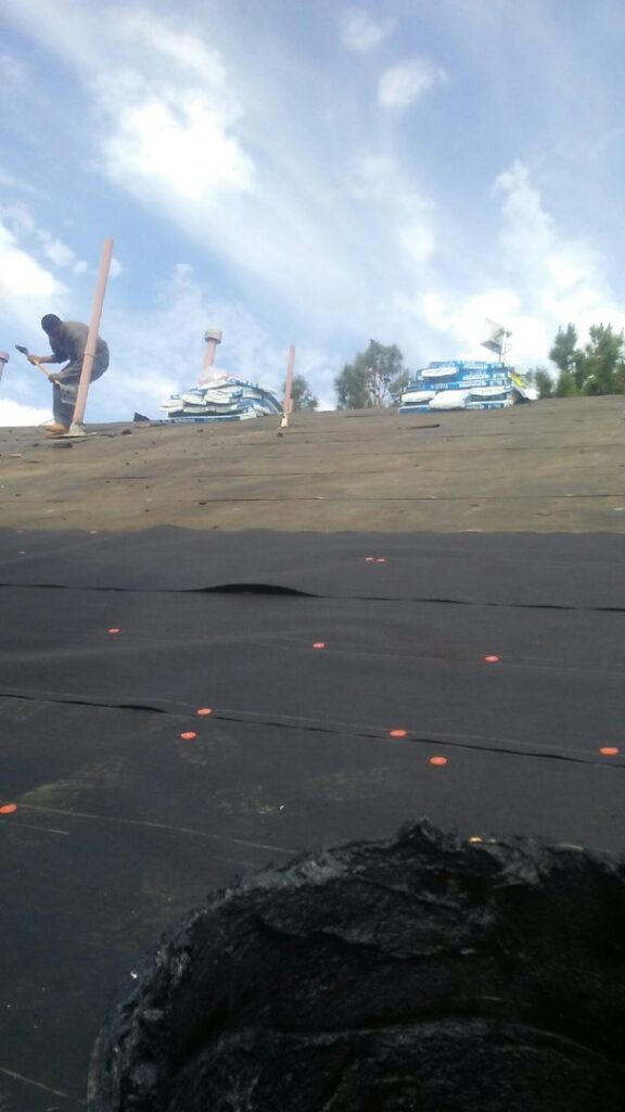 Roofing workers installing shingles on a house roof for Villalobos Remodeling & Construction in El Paso, TX