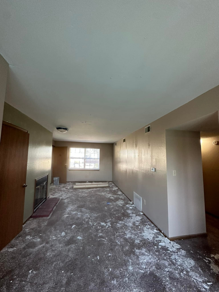 A room in disrepair with a messy floor and walls needing work, representing a 'before' renovation project by One Seven Painting LLC in Columbia, MO.