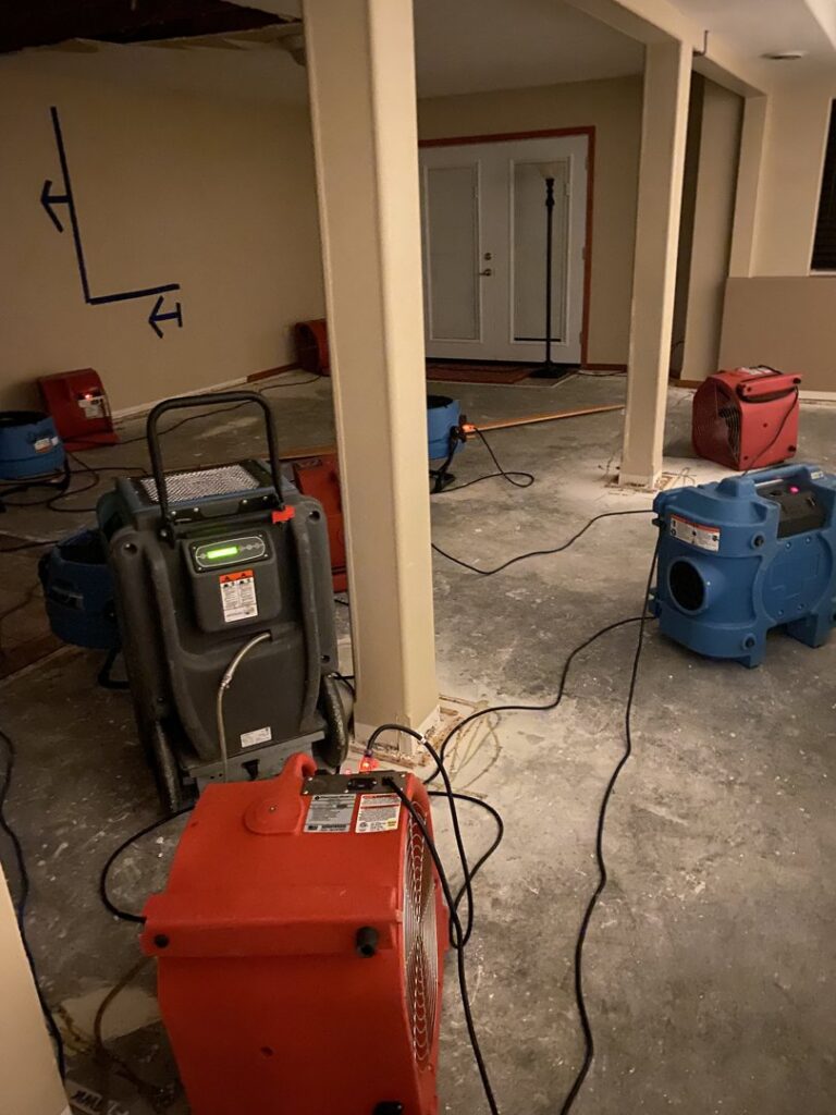 Room being dried with industrial fans and dehumidifiers for water damage restoration by Epic Electric, Heating, Cooling & Plumbing in Spokane, WA