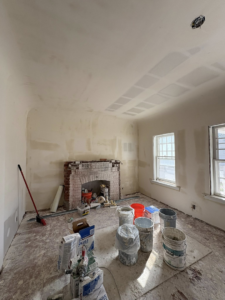 An interior room undergoing drywall repair and painting preparation with a brick fireplace by EJL Construction, LLC in Roswell, NM.