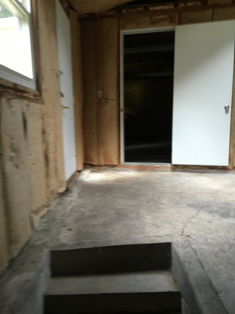 A room with exposed insulation and a concrete floor, indicating renovation work by Lemelin General Contracting in Fall River, MA.