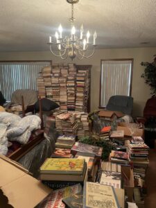A room completely filled with stacks of books and boxes, indicating a large cleanout job by AAA Rousse Junk Removal Services Inc of Florida in Tampa, FL.
