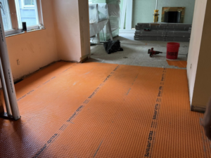 Room floor prepared with Schluter Ditra matting for tiling during a renovation by Jay's Construction in Cincinnati, OH.