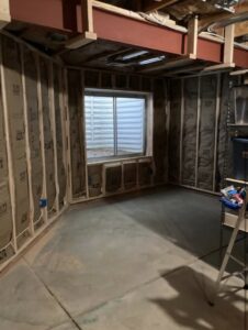 An interior room under construction, showing wall framing, insulation, and a newly installed window by DCM Multi Service llc in Harrisburg, PA.