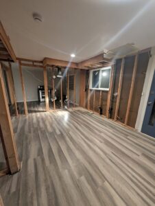 A room with exposed wood framing, plumbing, and electrical rough-ins during renovation by Asbestos Abatement, Inc in Englewood, CO.