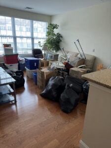 A room filled with moving boxes, black trash bags, and various household items, ready for cleanout by Junk Removal Brothers in Worcester, MA.
