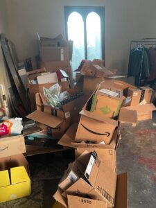 A room filled with numerous stacked cardboard boxes, indicating a junk removal service needed from Jax Junk Squad in Jacksonville, FL.