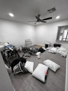 A room filled with bags, pillows, and metal frames, indicating a residential junk removal job by MLG Strong Hauling & Junk Removal LLC in Henderson, NV.