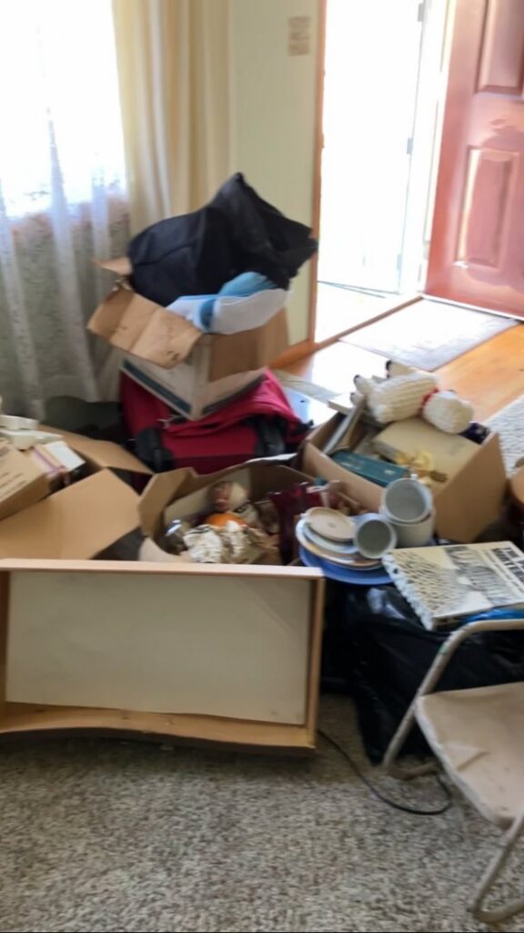 A room filled with boxes, trash bags, and various household items awaiting junk removal by HaulPros in Erie, PA.