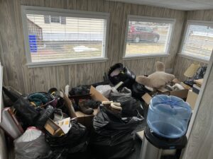A room filled with numerous trash bags, boxes, and miscellaneous junk, ready for removal by Tj's junk removal LLC in Derry, NH.