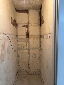 A finished room with hardwood floors, white walls, and recessed lighting by Borrelli Plastering & Sons in O'Fallon, MO.