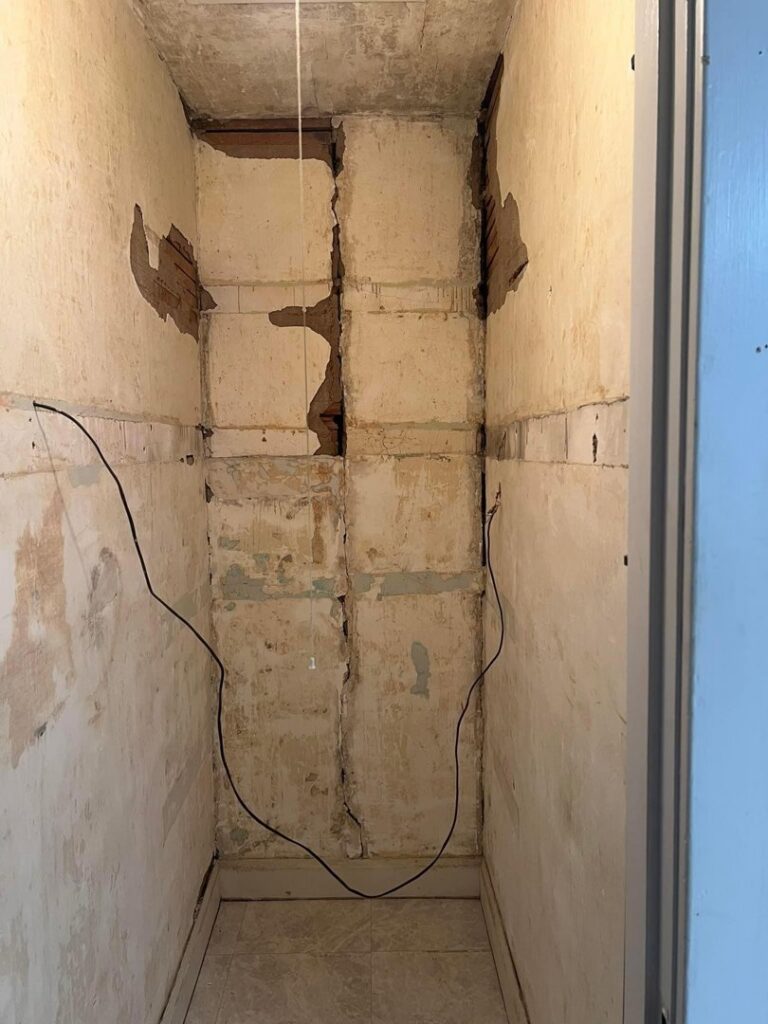 A finished room with hardwood floors, white walls, and recessed lighting by Borrelli Plastering & Sons in O'Fallon, MO.