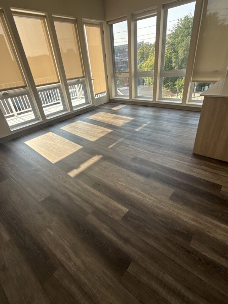 A bright room with large windows and new vinyl plank flooring installed by D E Custom Floors in Waukesha, WI.