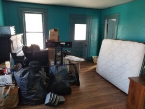 A room filled with a mattress, black trash bags, boxes, and other items awaiting junk removal by CC JUNK Removal in Corpus Christi, TX.